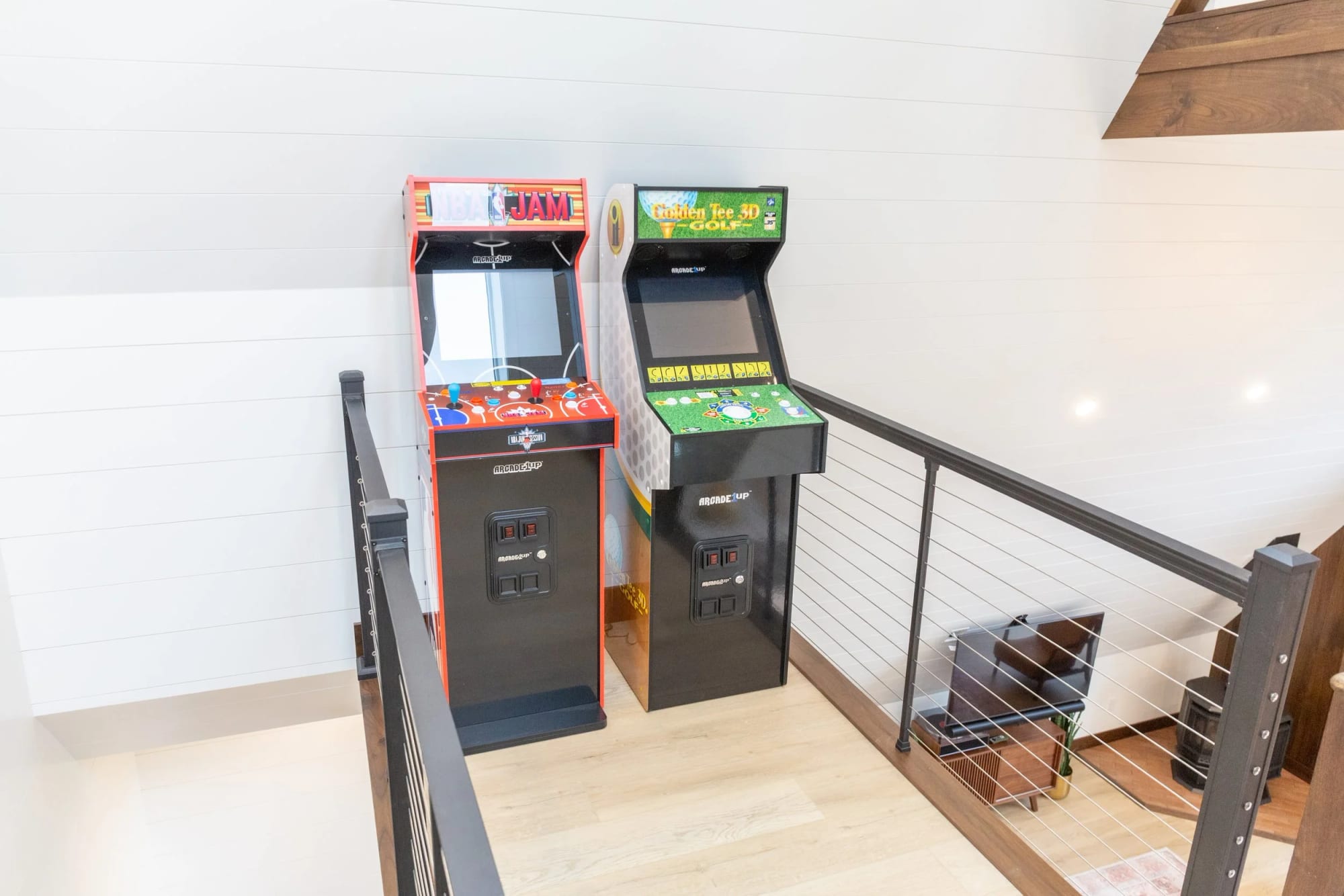 Two arcade cabinets beside the loft railing