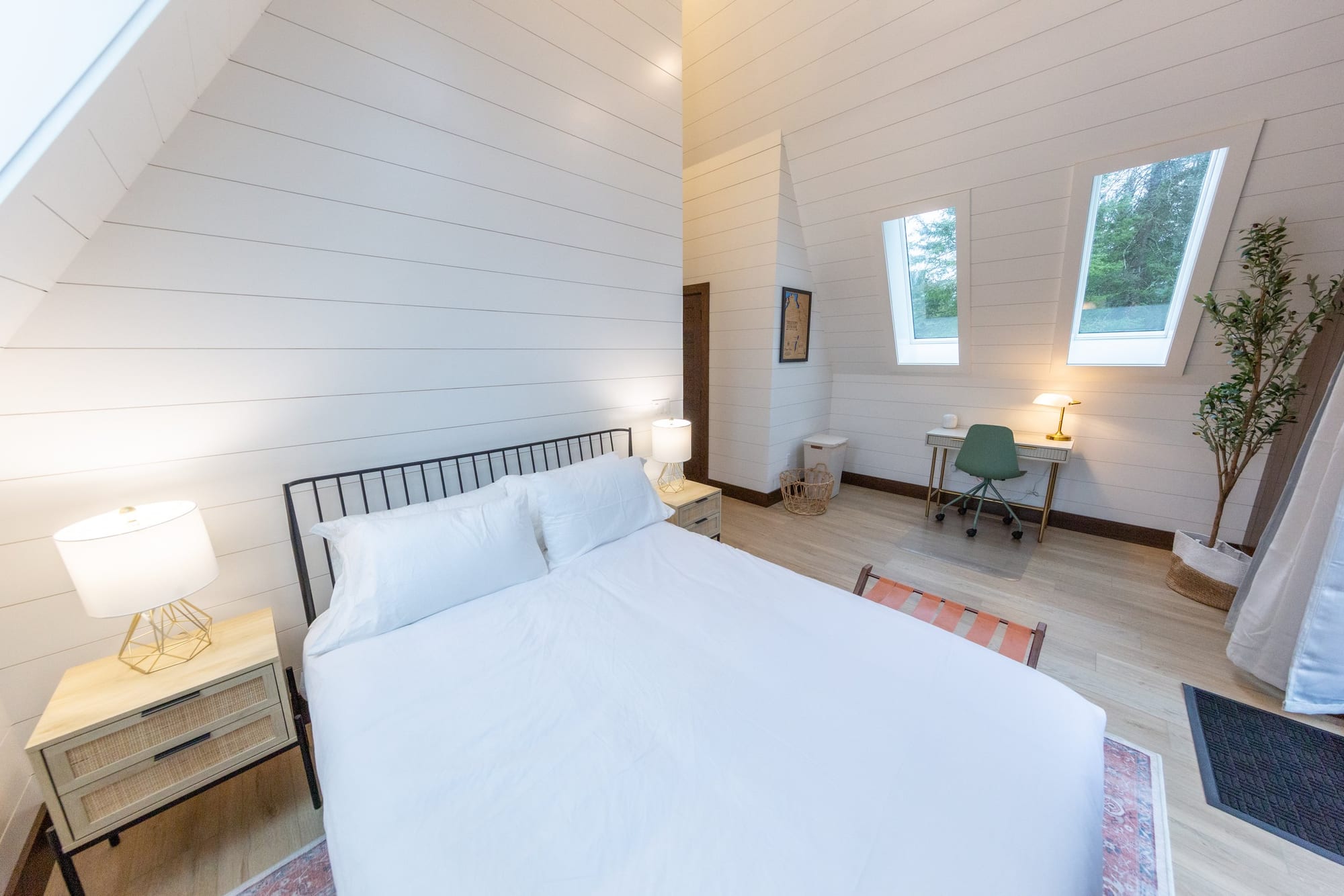 A bedroom under the roof pitch with skylights and a desk