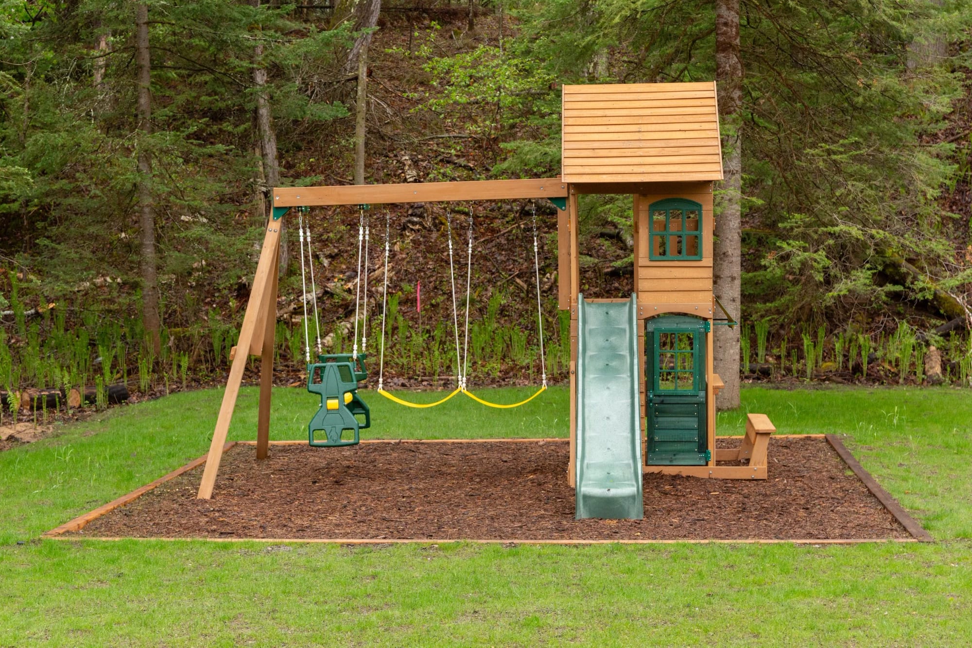 The outdoor playset at the edge of the lawn